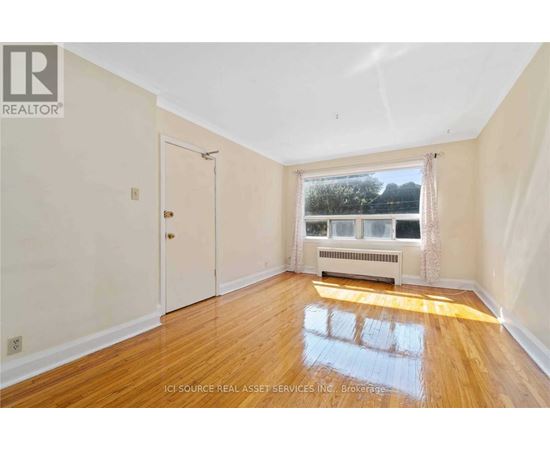 A room with wooden floors and a window overlooking a body of water.