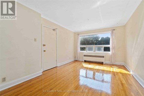 A room with wooden floors and a window overlooking a body of water.