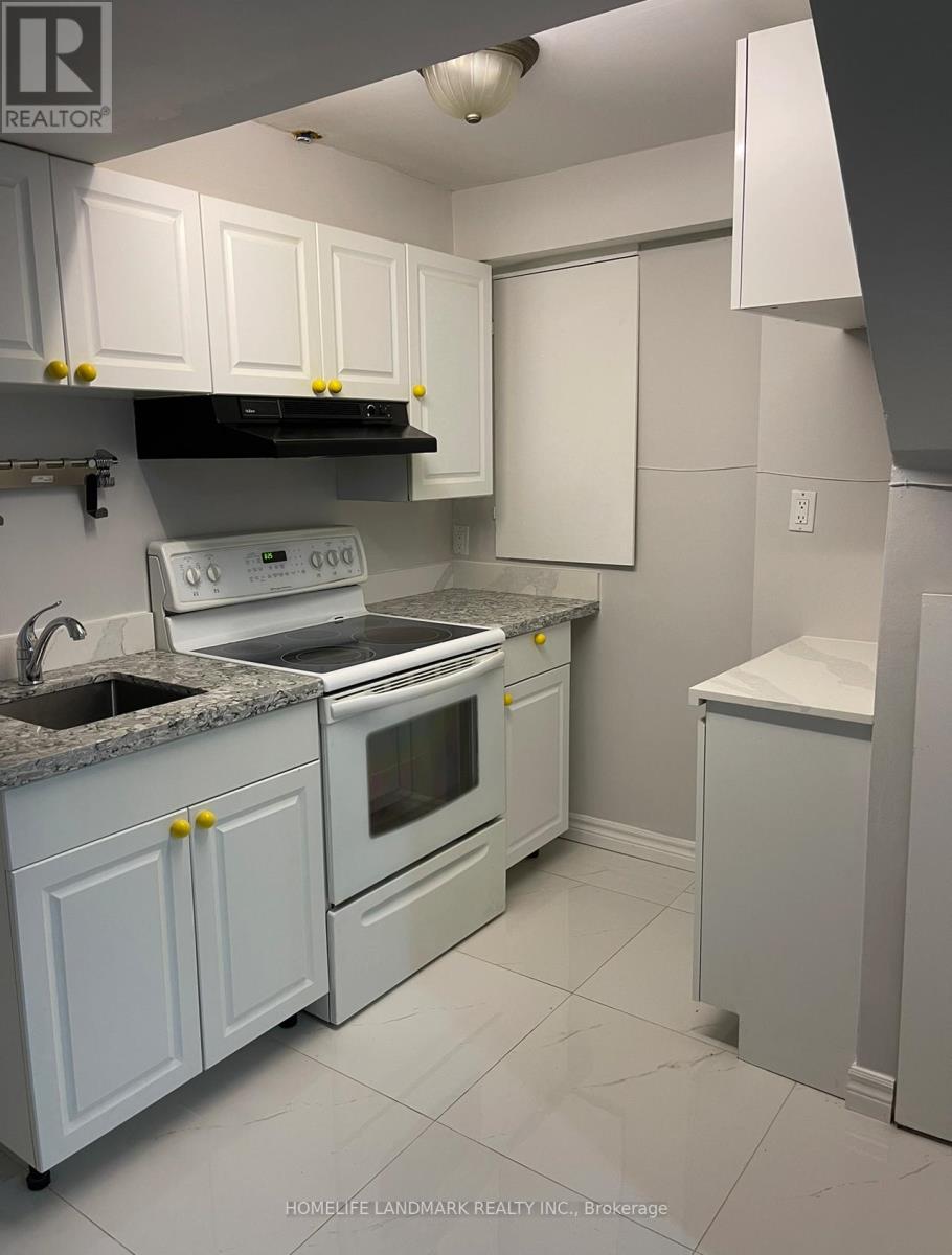 A white kitchen with a sink, stove, and refrigerator.
