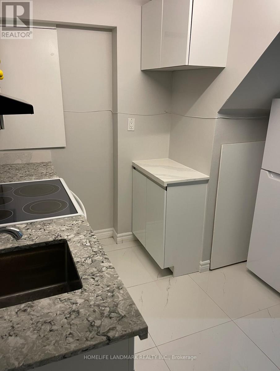 A kitchen with a sink and a refrigerator.