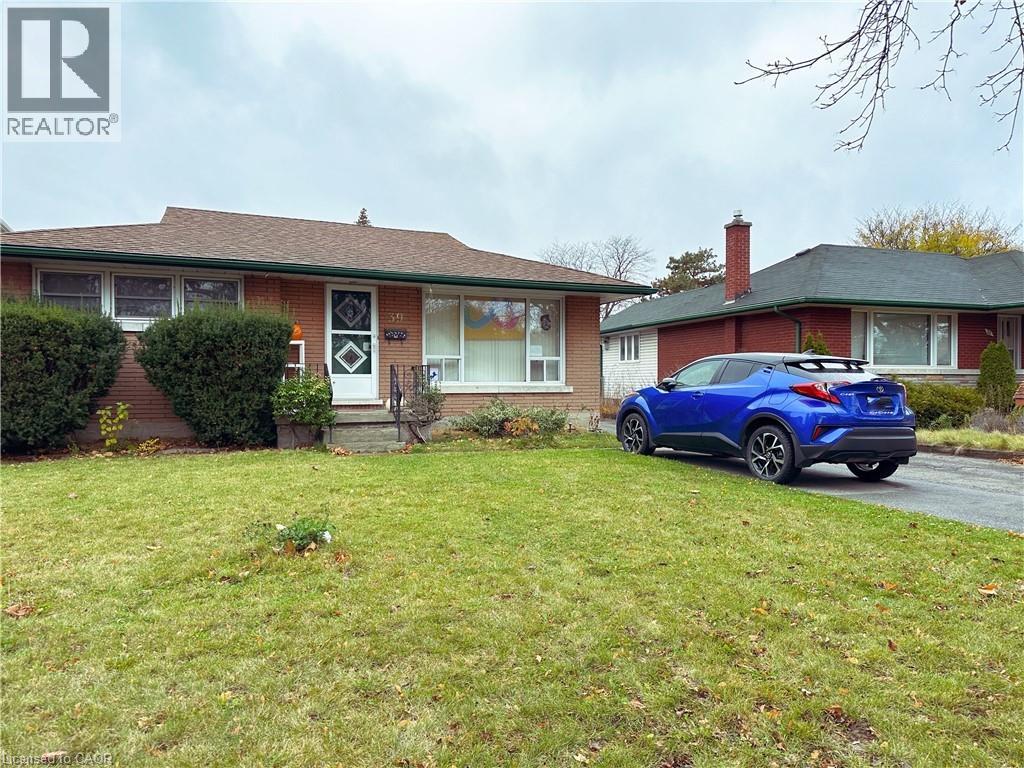 A blue car is parked in front of a house with a sign that says REALTOR.