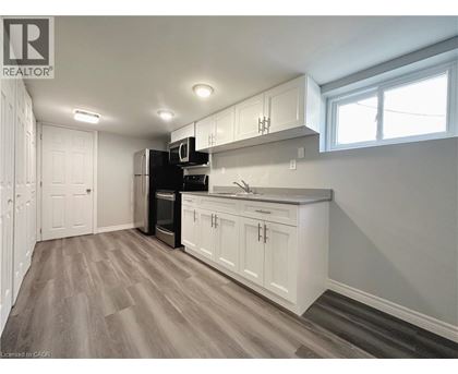 A kitchen with white cabinets and a wooden floor.