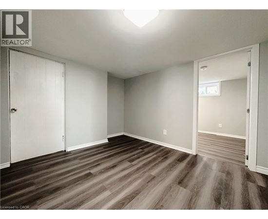 A room with wood flooring and white walls.