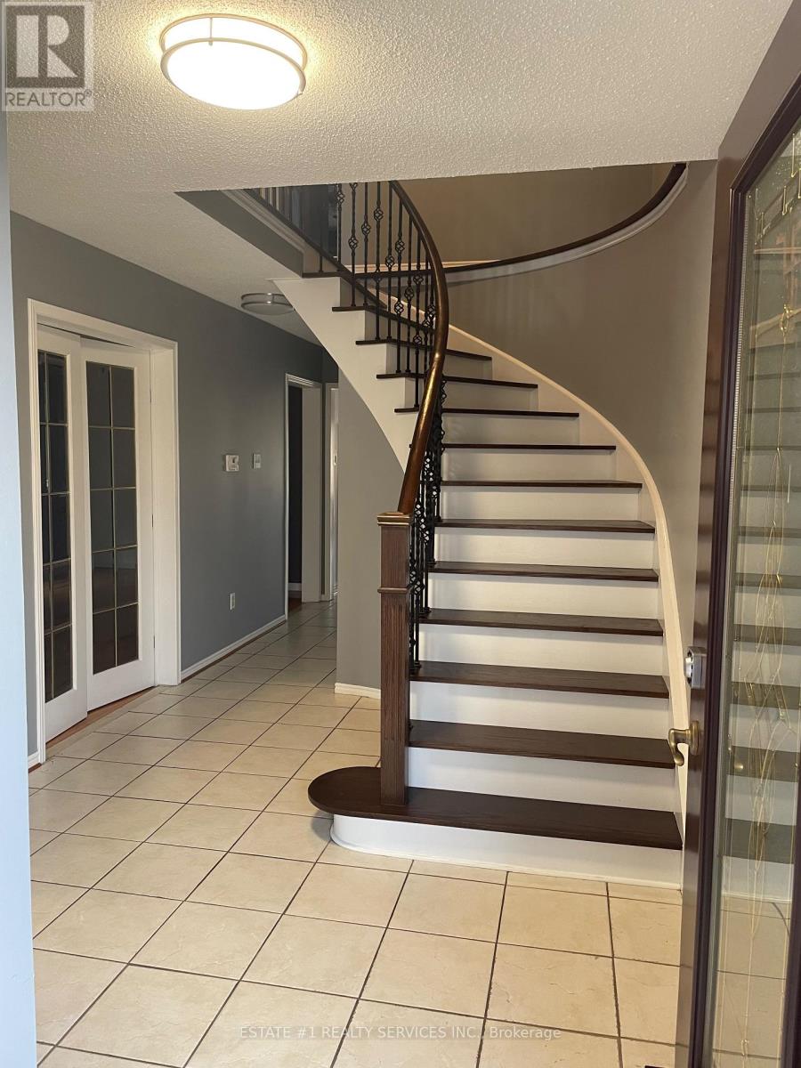 A spiral staircase in a home with a glass door on the right side.