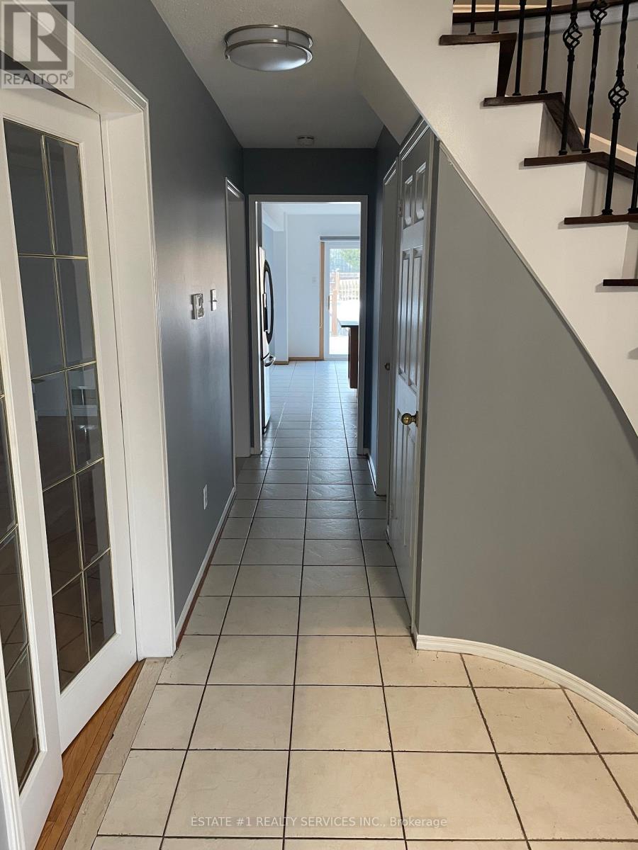 A hallway with a staircase on the right and a door on the left.