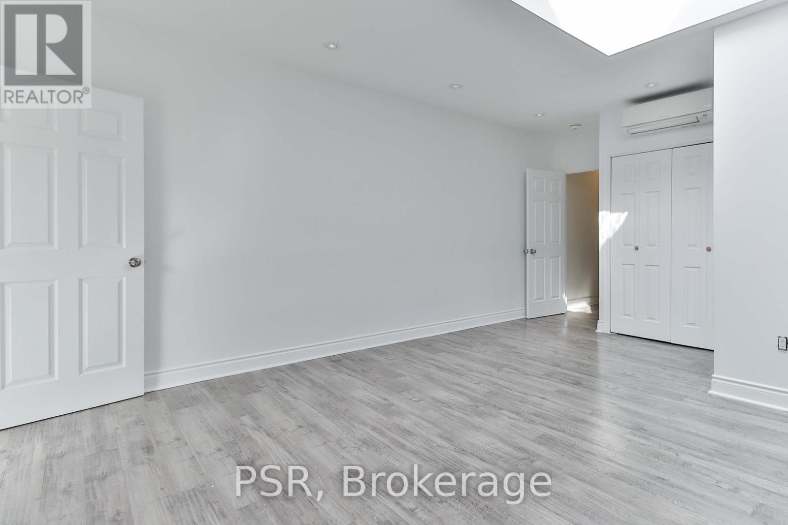 A room with white walls and a wooden floor.