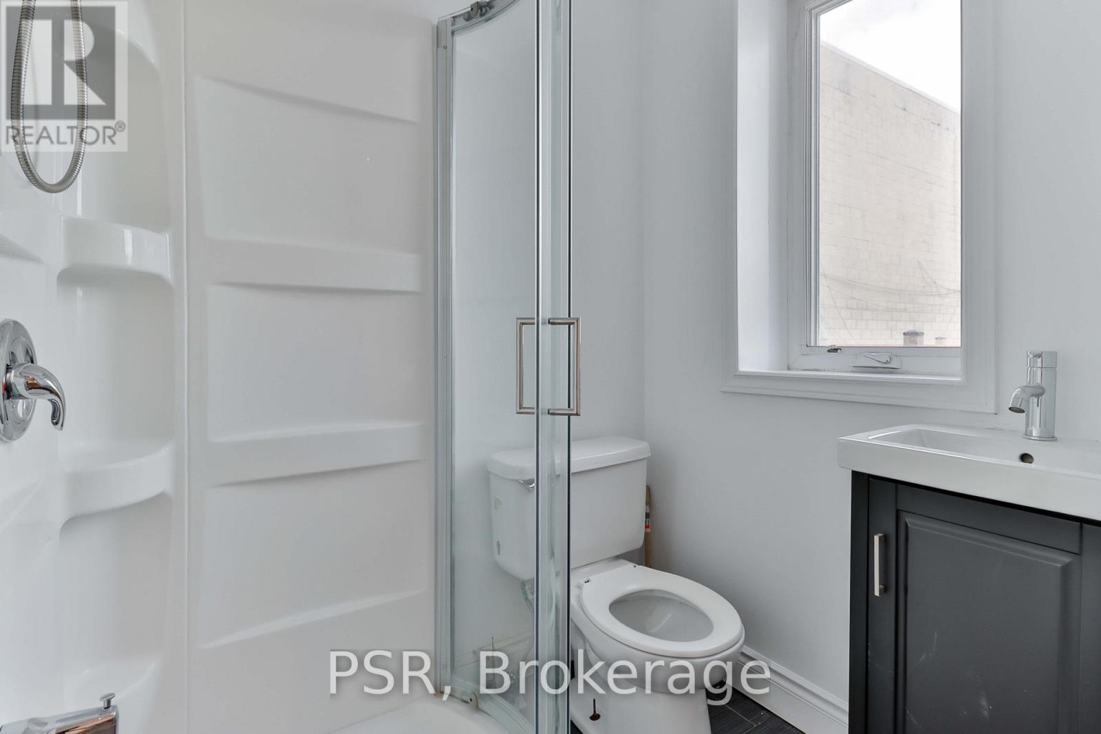 A bathroom with a toilet, sink, and shower.
