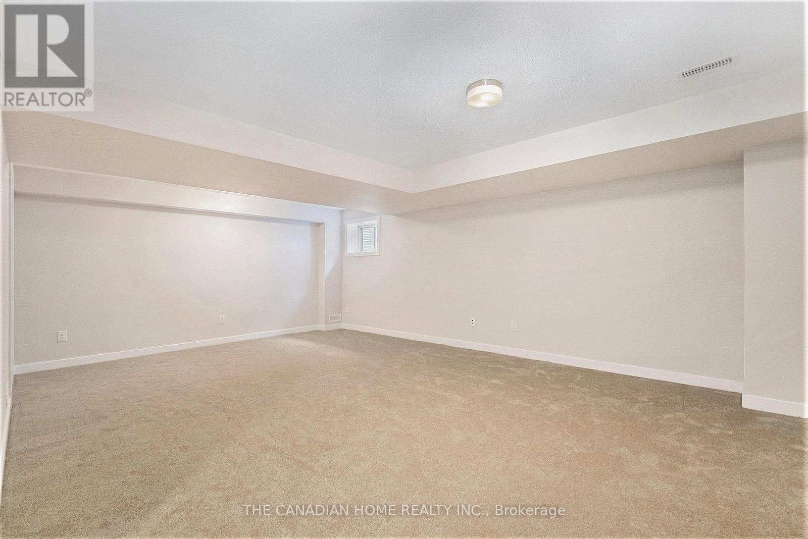 A spacious room with beige carpeting and white walls, likely a bedroom or living space.