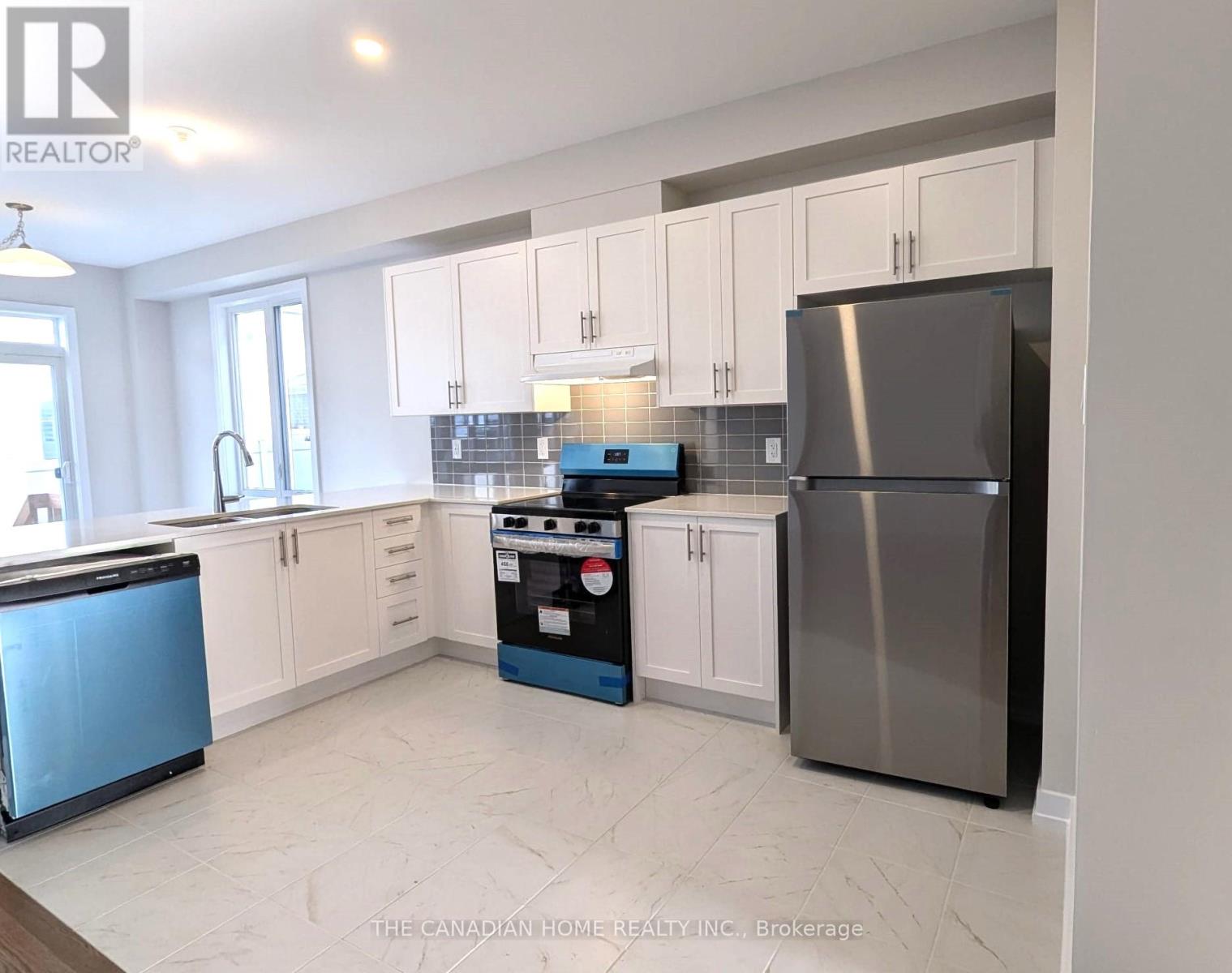 A kitchen with a blue dishwasher and a stove top oven.