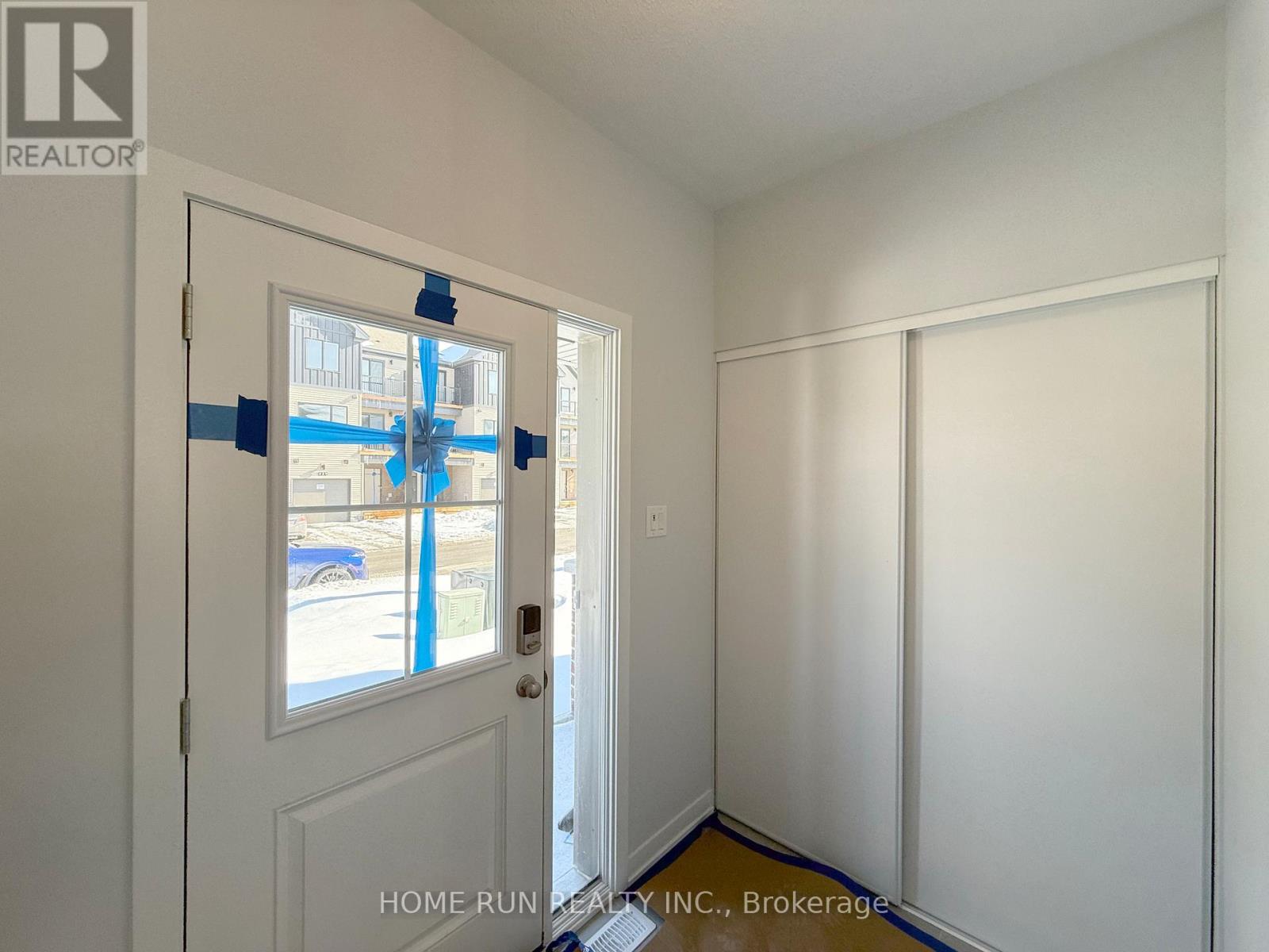A room with a door and a wall with tape on it.