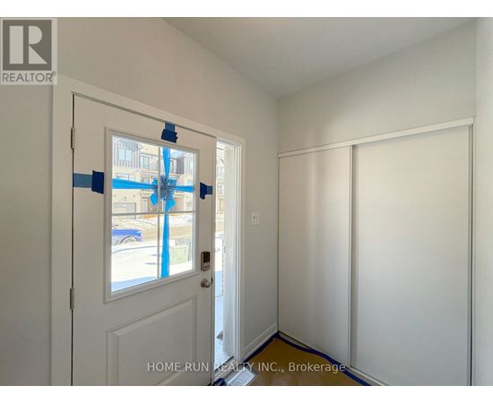 A room with a door and a wall with tape on it.