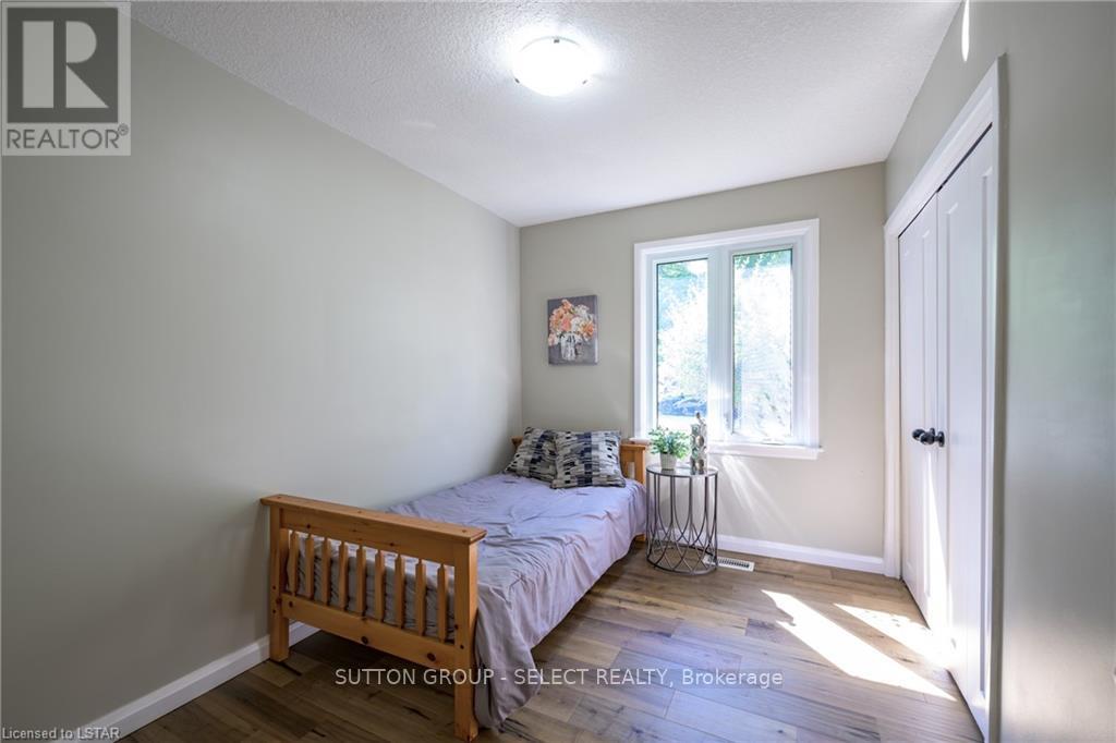 A bedroom with a bed, nightstand, and window.