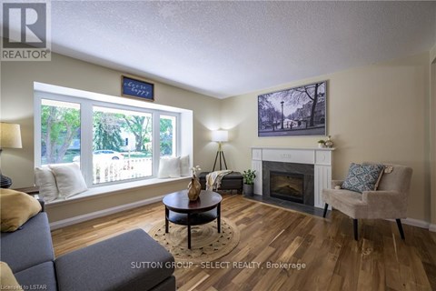 A living room with a fireplace and a painting on the wall.