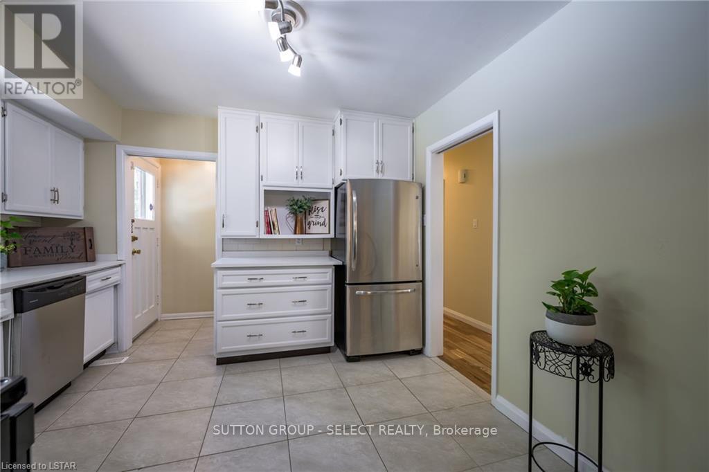 A kitchen with white cabinets and a refrigerator.