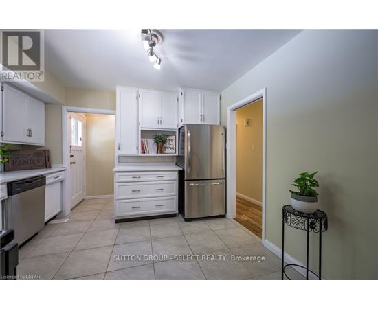 A kitchen with white cabinets and a refrigerator.