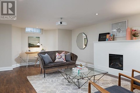 A living room with a grey couch and a glass coffee table.