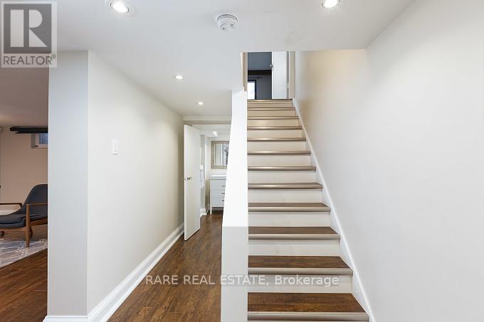 A staircase in a house with a brokerage sign.