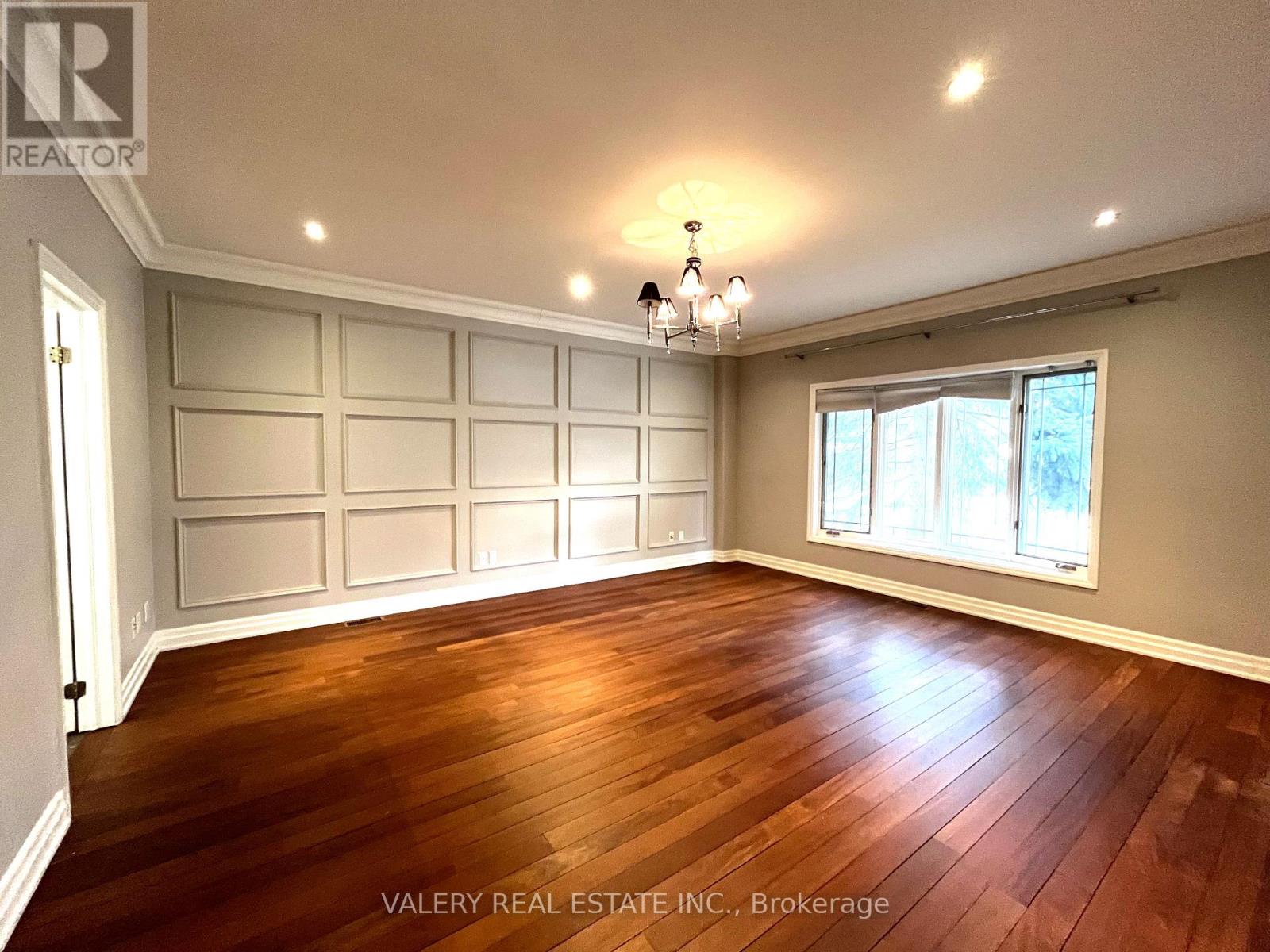 A room with wooden floors and a chandelier.