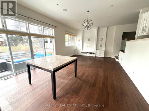 A dining room with a wooden table and chairs in a house.