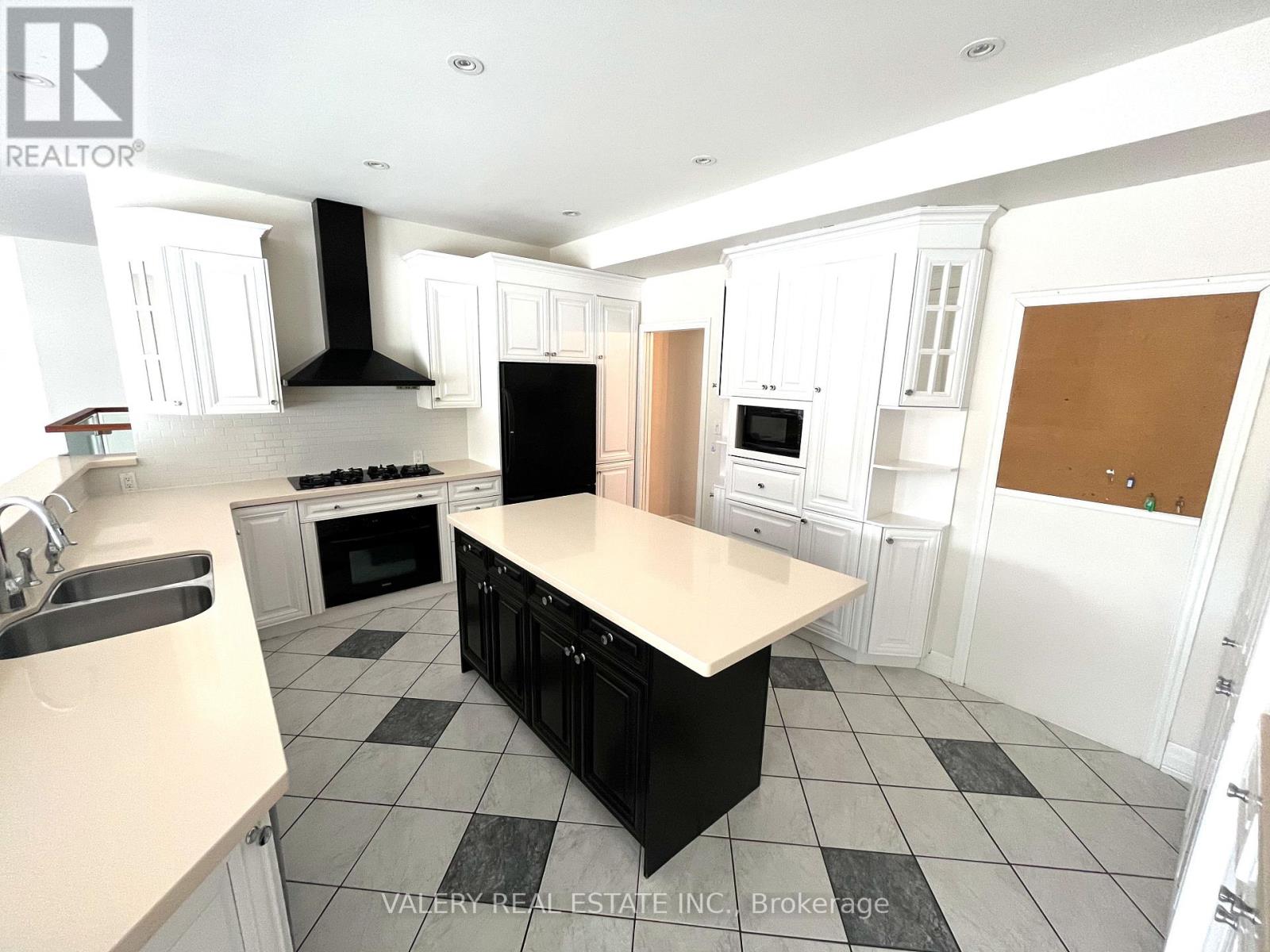 A kitchen with black and white appliances and cabinets.