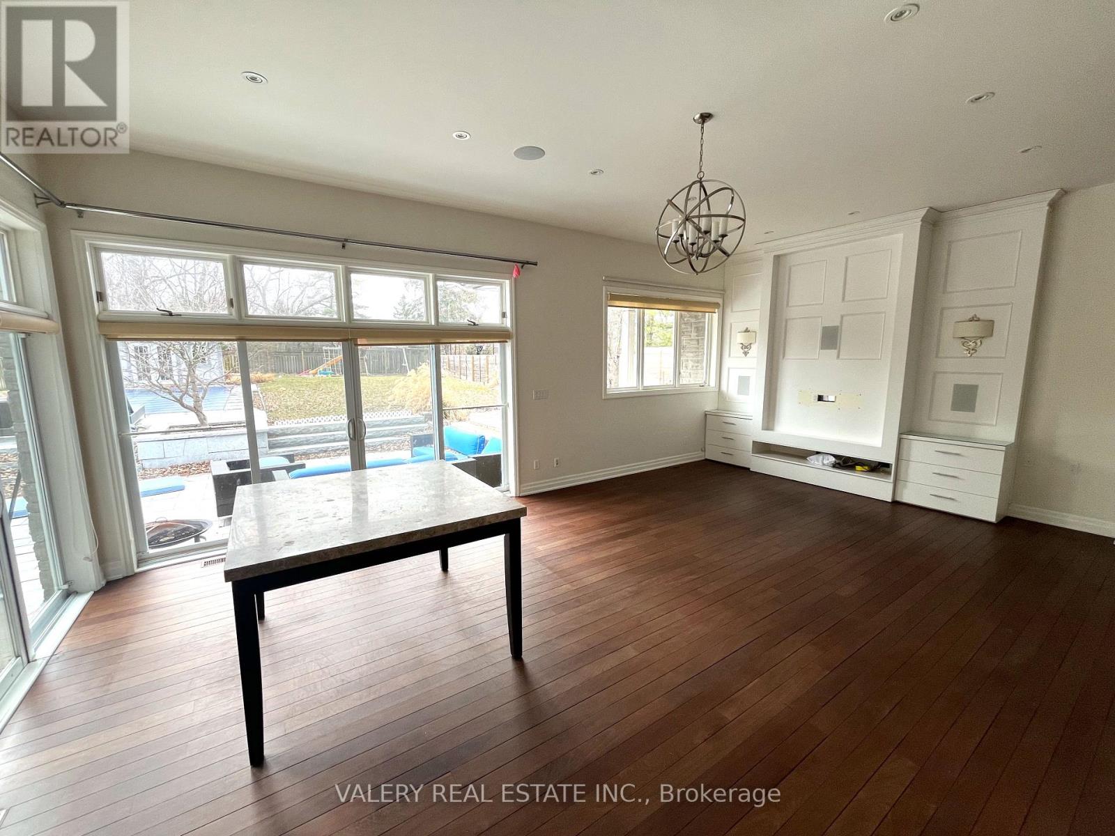 A room with wooden floors and a large window overlooking a pool.