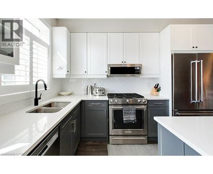 A modern kitchen with a stainless steel refrigerator and a black oven.