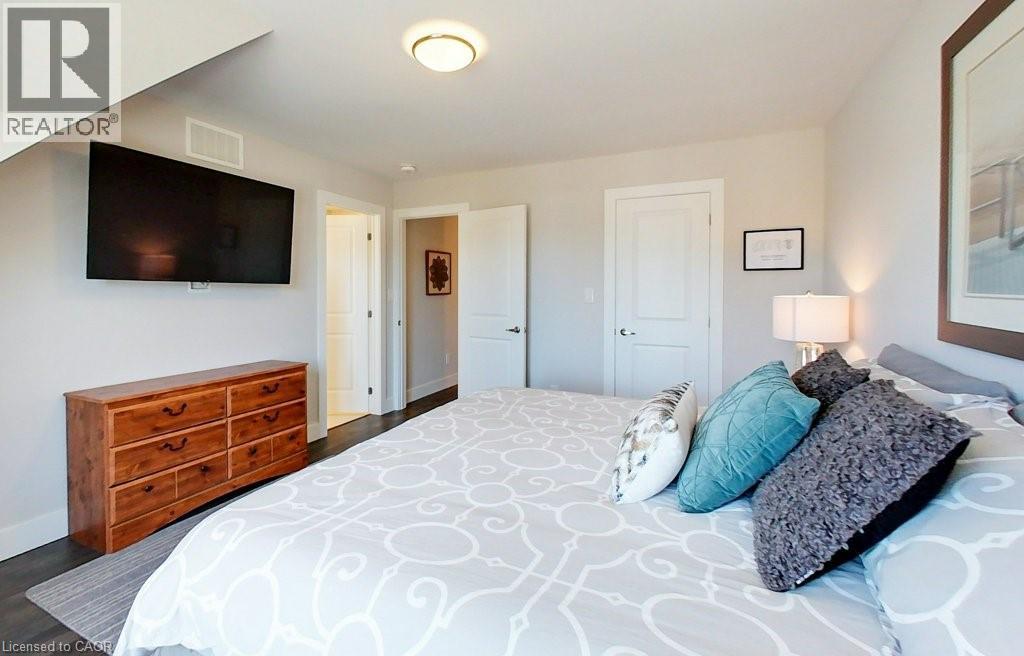 A bedroom with a large bed and a flat screen TV mounted on the wall.