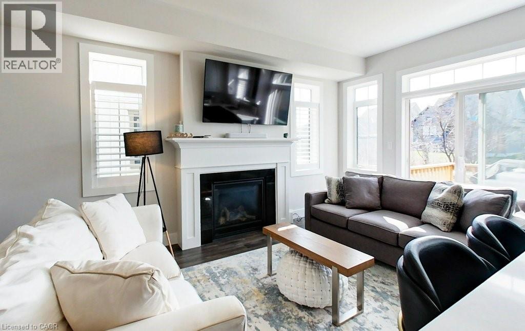 A living room with a fireplace and a television on the wall.