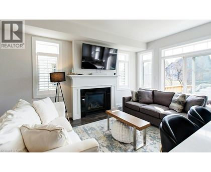 A living room with a fireplace and a television on the wall.