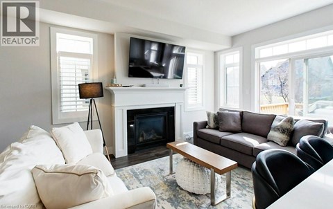 A living room with a fireplace and a television on the wall.
