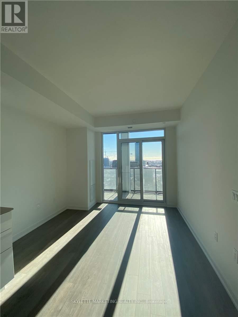 A spacious room with a view of the city through the glass doors.