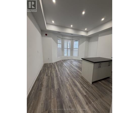 A spacious room with wood flooring and a cabinet.