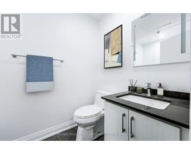 A bathroom with a toilet, sink, and a mirror.