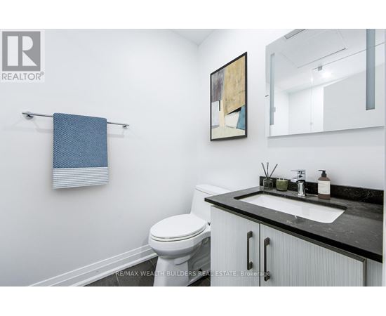 A bathroom with a toilet, sink, and a mirror.