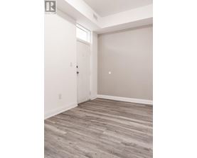 A room with a white door and a wooden floor.