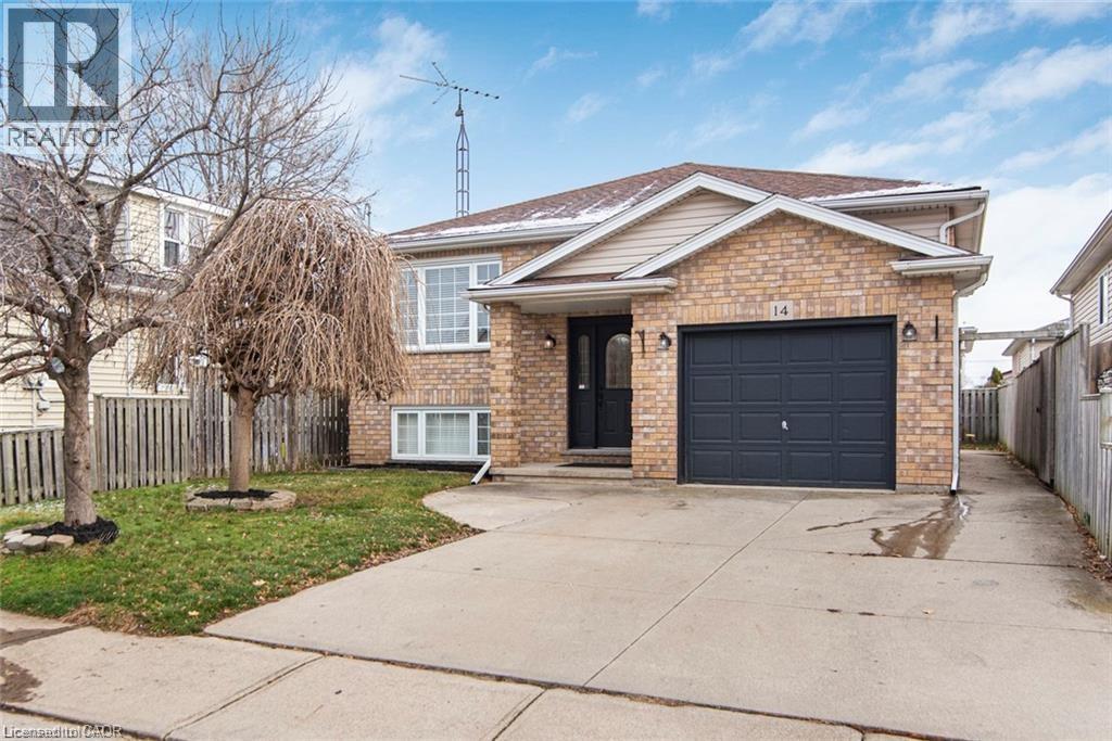 A house with a brick facade and a black garage door is for sale.