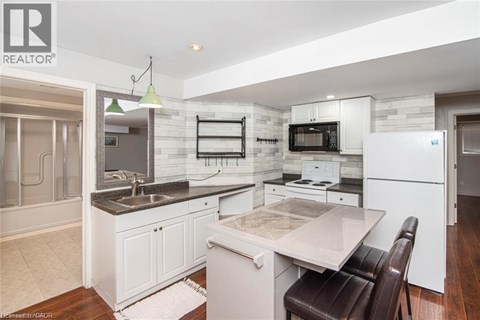 A modern kitchen with white cabinets and a marble countertop.