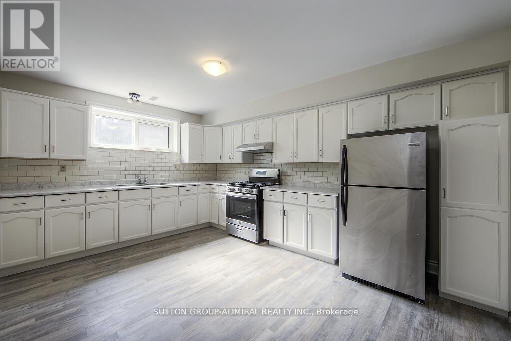 A kitchen with white cabinets and a refrigerator.