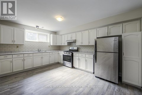 A kitchen with white cabinets and a refrigerator.