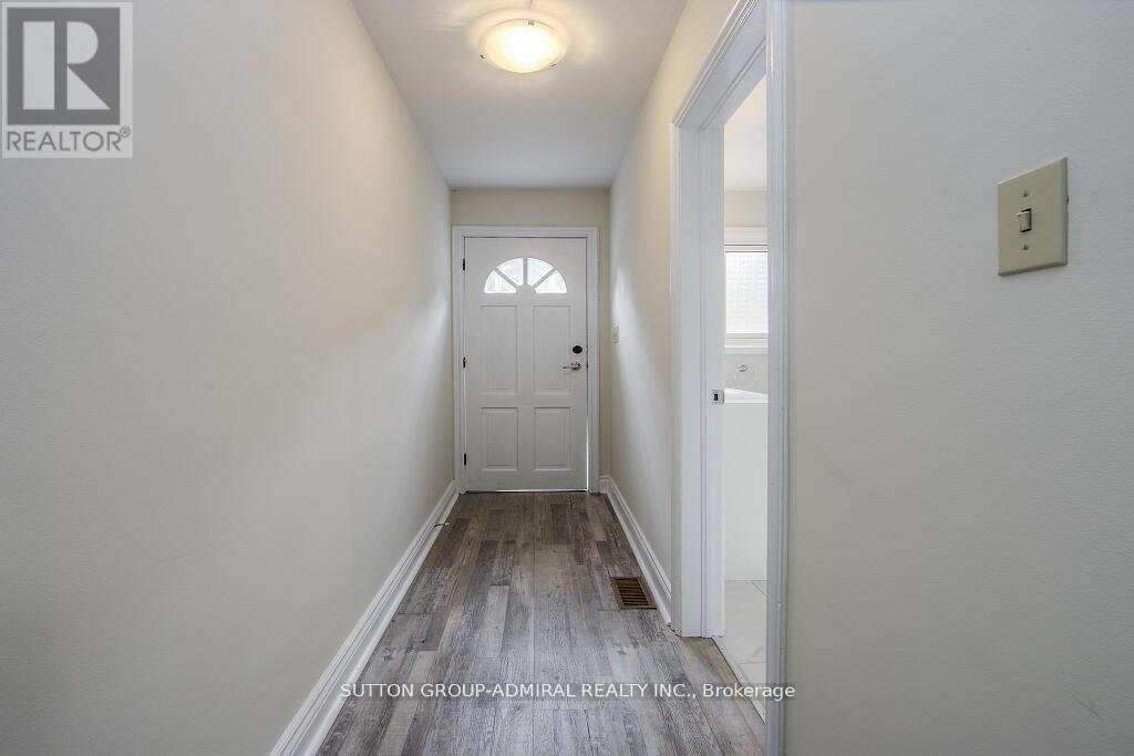 A hallway with a door and a light on the ceiling.
