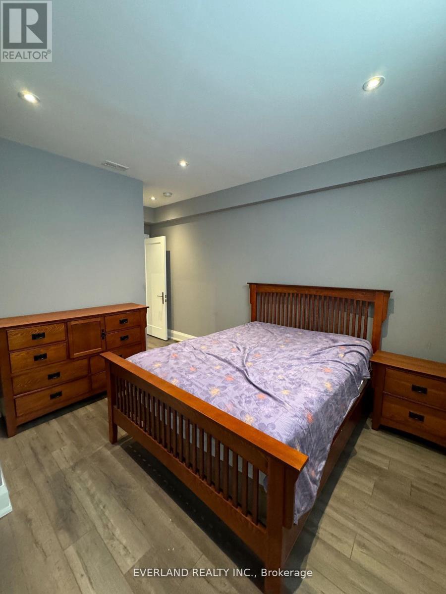A bedroom with a bed, dresser, and nightstand.
