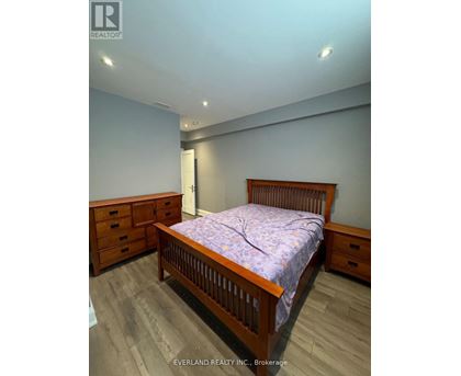 A bedroom with a bed, dresser, and nightstand.