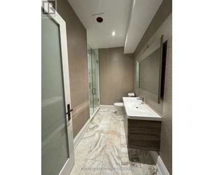 A bathroom with a marble floor and a white sink.
