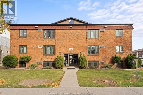 A brick building with a black door and windows.
