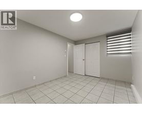 A white room with a tile floor and a door.
