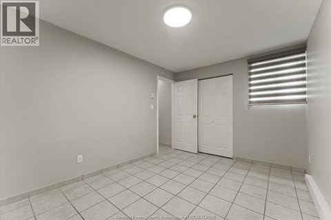 A white room with a tile floor and a door.