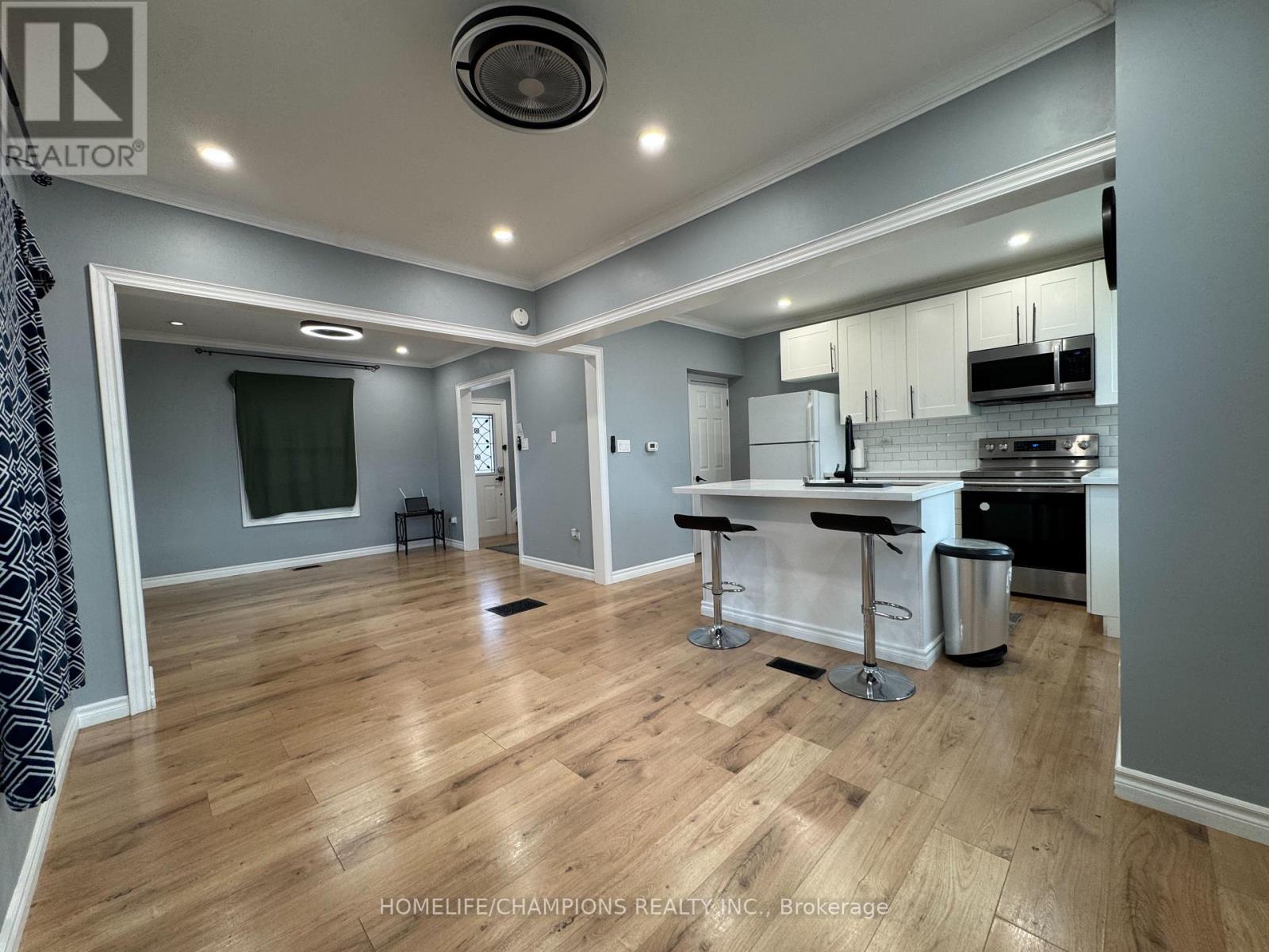 A kitchen area with a bar stool and a counter.