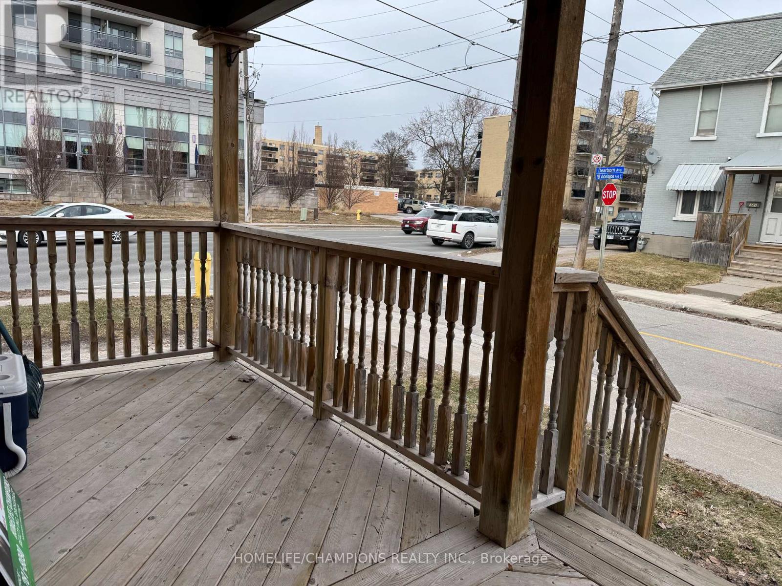 A wooden deck overlooks a street with cars and buildings.