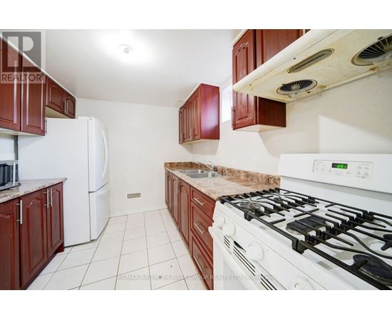 A kitchen with a white gas stove and brown cabinets.