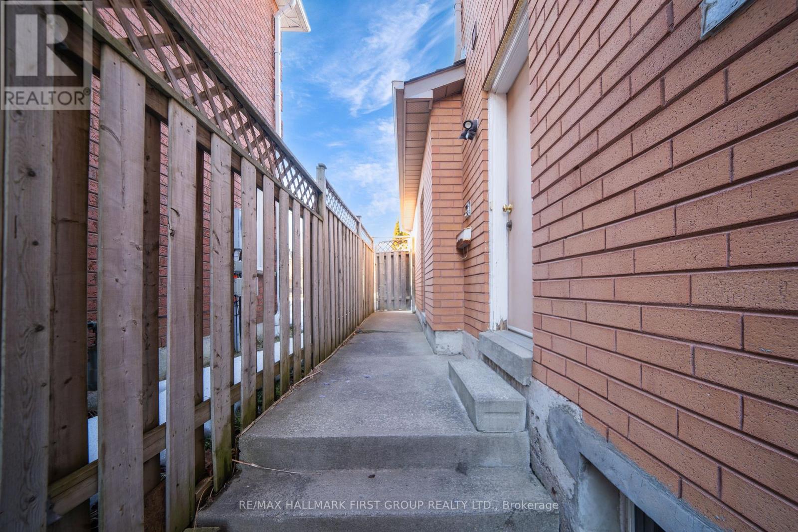 A long, narrow alleyway between two red brick buildings.